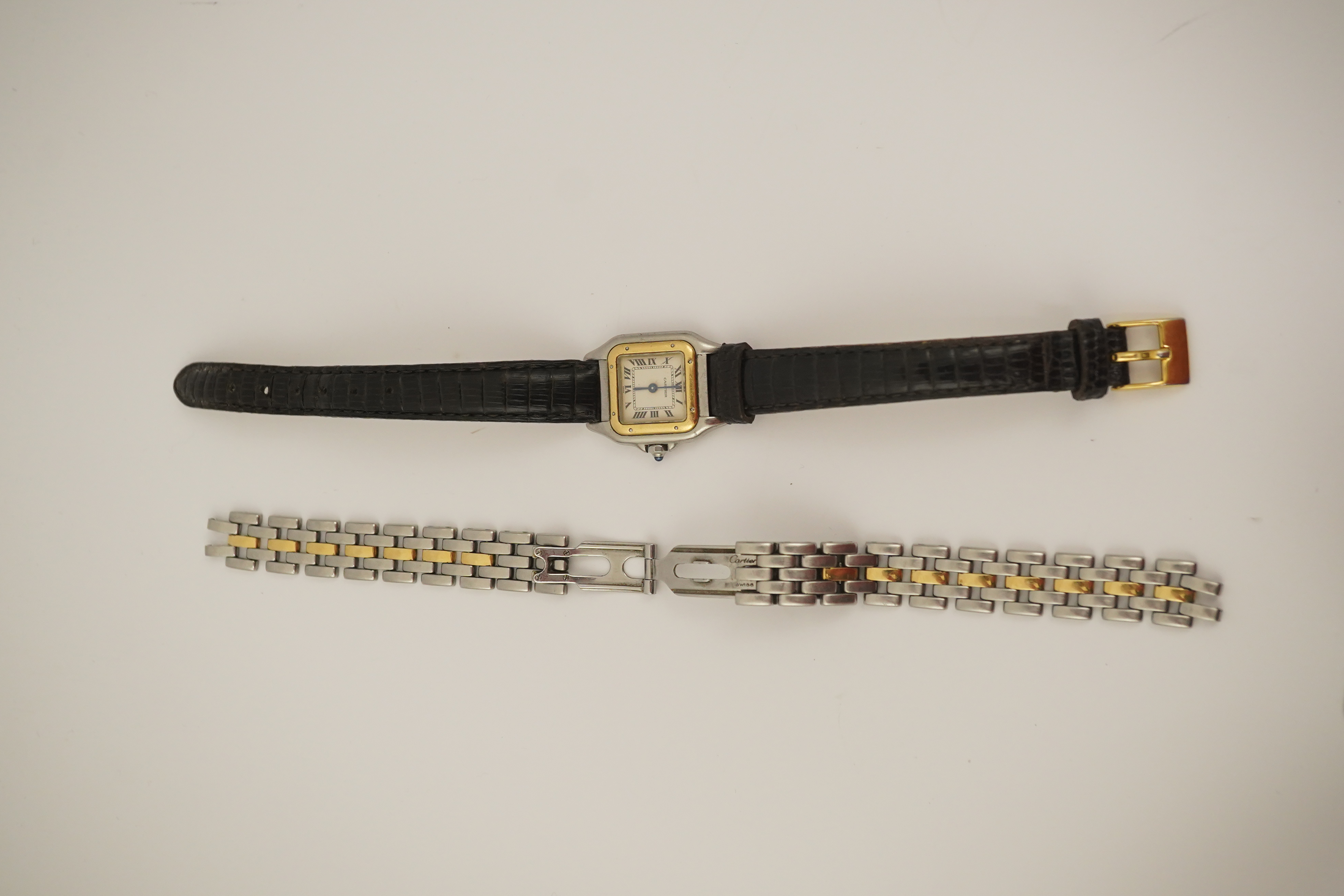 A lady's steel and gold Cartier Panthere quartz wrist watch, now on an associated leather strap, but with original Cartier steel and gold bracelet (lacking end bars)